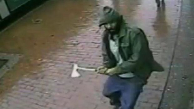 An unidentified man approaches New York City police officers with a hatchet in the Queens borough of New York in image taken from video. 