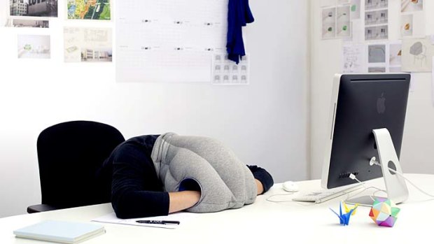 The Ostrich Pillow in use at a desk.