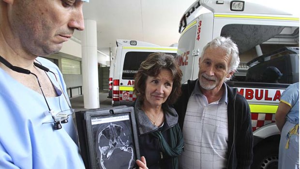Dr Tony Grabs, head of trauma at St Vincent's Hospital, shows a scan of Simon Cramp's injury to his parents, Angela and Phillip.