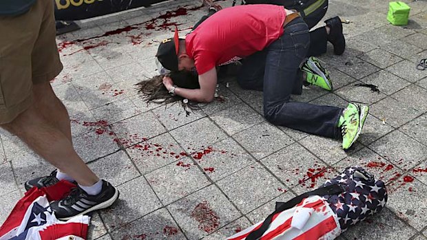 A man comforts a victim after the first bomb blast.