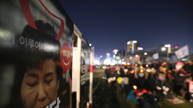 A poster showing a portrait of impeached President Park Geun-hye is displayed during a candle light vigil calling for Park to step down in Seoul.