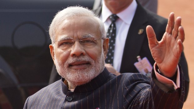 Indian Prime Minister Narendra Modi wears a dark pinstriped suit with his name monogrammed in dull gold stripes during a reception for US President Barack Obama in New Delhi, India.  Modi's suit was auctioned on Friday for a whopping sum of nearly $883,000.
