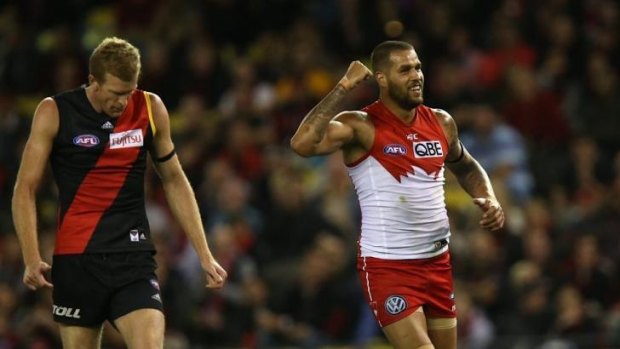 Lance Franklin shakes his fist in triumph after kicking a goal as Dustin Fletcher watches.