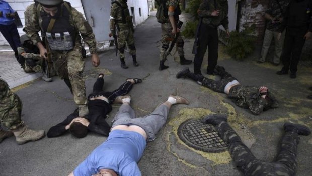 Ukrainian servicemen detain men at a site of battle with pro-Russian separatists in the eastern Ukrainian port city of Mariupol.