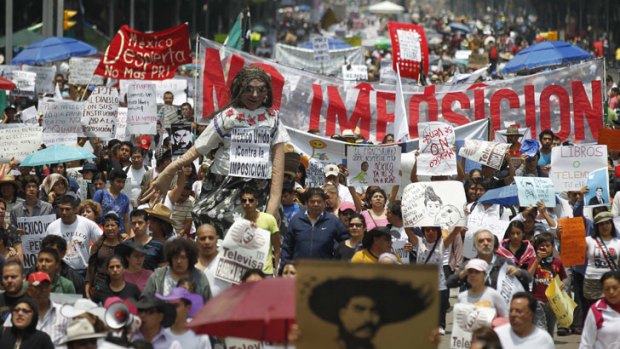 Tens of thousands of protesters in Mexico City take part in a march against Mexico's president-elect Enrique Pena Nieto, whom they accuse of buying votes to win the presidency.