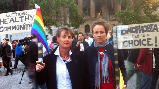 Cath Ovenden and Nicole Gaunt are among 800 people protesting funding cuts to gay health group Healthy Communities at King George Square.