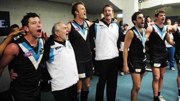 Matthew Primus (centre) celebrates with his players after Port Adelaide defeated the Crows in July.
