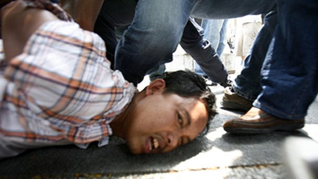 Chaos in Kuala Lumpur ... a protester is arrested on the street.