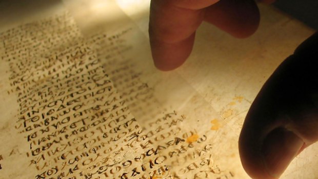 A reader examines a page from the earliest surviving Christian Bible.  The British Library says the surviving pages of the world's oldest Bible have been reunited digitally.