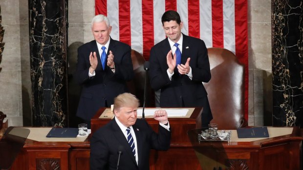 President Donald Trump, flanked by Vice President Mike Pence and House Speaker Paul Ryan, gestures on Capitol Hill in Washington, on Tuesday.