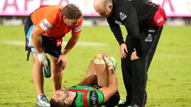 Greg Inglis clutches at his leg while being treated on the pitch on Saturday night.