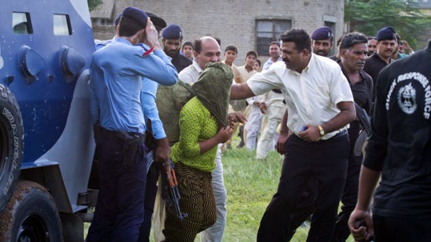 Heavily armed security officials rush Rimsha Masih, a Christian girl accused of blasphemy, to a military helicopter to fly her to a secret location.