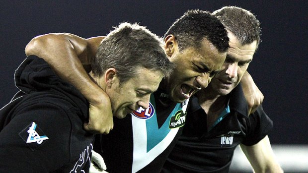 Port Adelaide’s David Rodan is helped from the field by club doctors during the clash at AAMI Stadium.