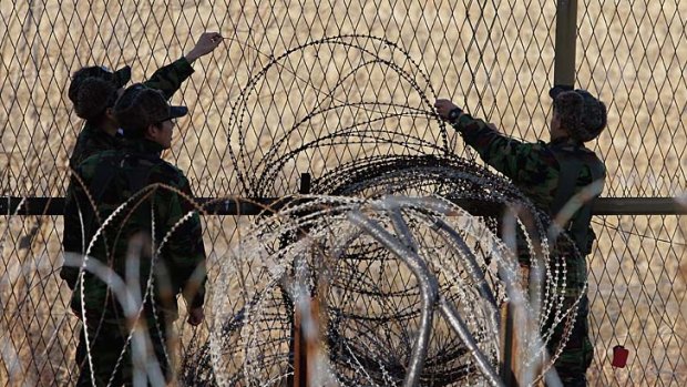 South Korean soldiers check the barbed wire fence at Imjinkak near the demilitarised zone separating North and South Korea.