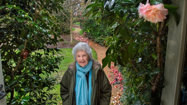 Tamie Fraser in her garden flanked by two 'Tamie' camellias.