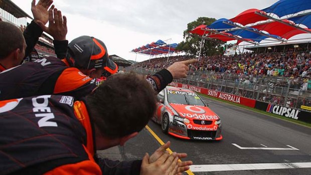Jamie Whincup is cheered by his crew after winning race four of the Clipsal 500 in a soggy Adelaide yesterday.