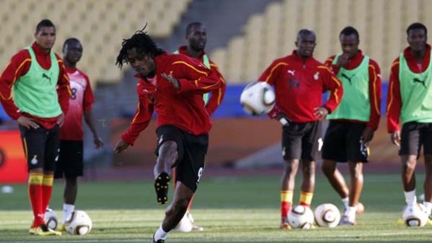 Ghana's Derek Boateng (centre) shoots the ball next to teammates during a training session.