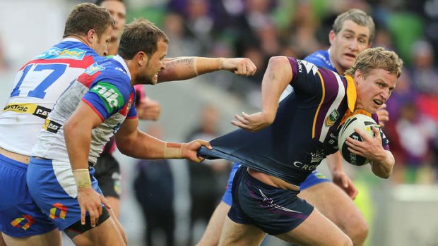 Shirt tails: Storm's Brett Finch runs past Newcastle players who failed to break their jinx, losing their 10th straight in Melbourne.