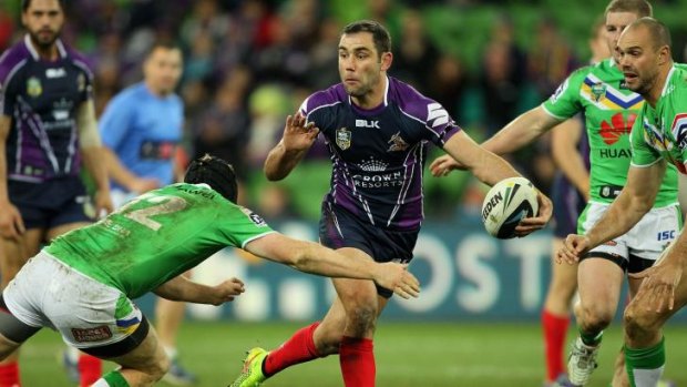Melbourne Storm captain Cameron Smith gets a pass away under pressure from the Raiders' defence. 