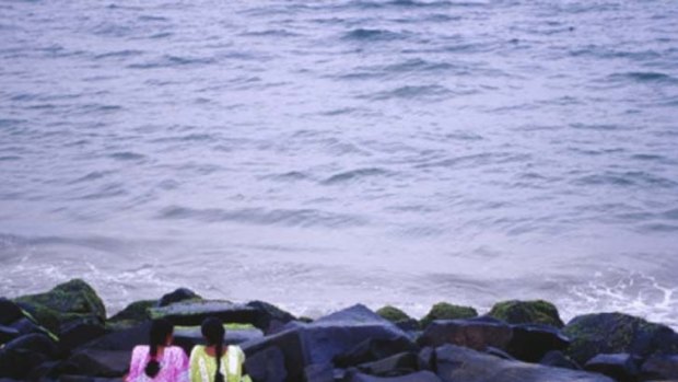 On golden Pondy ... women rest on the rocks at Pondicherry's City Beach.