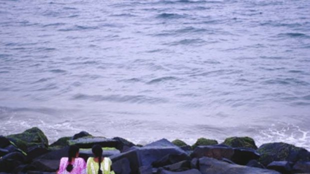 On golden Pondy ... women rest on the rocks at Pondicherry's City Beach.