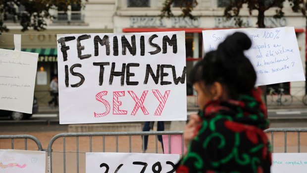 A woman reads a banner during a demonstration to support the wave of testimonies denouncing cases of sexual harassment, in France in the wake of mounting allegations against Hollywood mogul Harvey Weinstein last month.