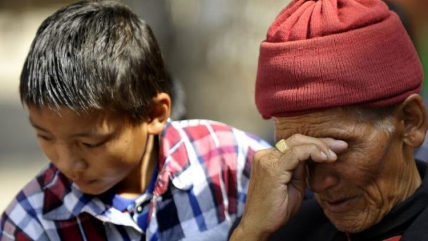 The father and son of Mount Everest avalanche victim Ang Kazi Sherpa comfort each other as they wait for his body to arrive at Sherpa Monastery in Kathmandu last week.