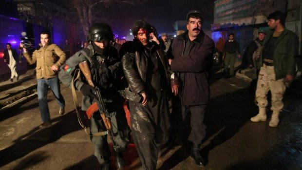 Aftermath: Afghan security forces assist an injured man at the site of the attack. 