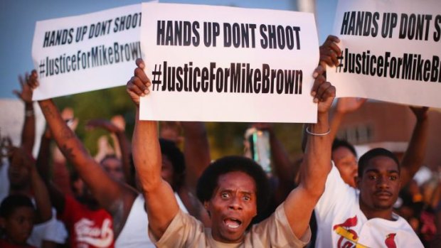 Demonstrators protest the killing of teenager Michael Brown outside Greater St Marks Family Church while Browns family along with civil rights leader Reverend Al Sharpton met inside to discuss the killing in St Louis on Monday. 