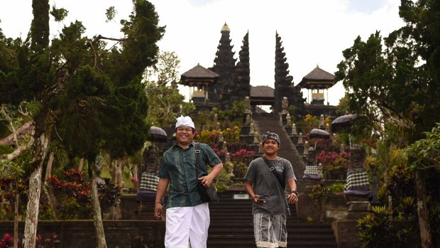 Pande Togi (left) and Komang Irvan (right) come down the steps after praying at the Besakih Mother Temple inside the 9km danger zone despite Mount Agung threatening to erupt. The Besakih Mother Temple is a famous Balinese tourist spot attracting hundreds of tourists a day. Tourists are staying away as Mount Agung threatens to erupt. Bali, Indonesia. 