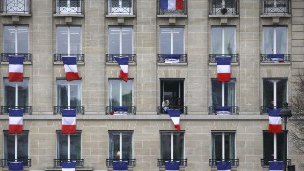 French flags hang along a building near where a memorial ceremony took place at the Les Invalides in Paris on Friday. 