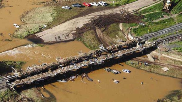 Cars and debris piled up on a railway bridge on the Lockyer River near Grantham.