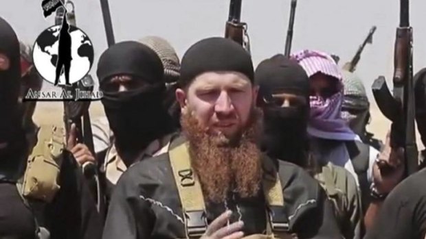 Inviting Muslims to join from abroad ... Islamic State of Iraq and the Levant spokesman Omar al-Shishani, a Georgian, stands among a group of fighters as they declare the elimination of the border between Iraq and Syria. 
