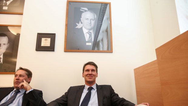 Senator Cory Bernardi sits under a portrait of Prime Minister Malcolm Turnbull in the joint party room meeting at Parliament House in Canberra last year.