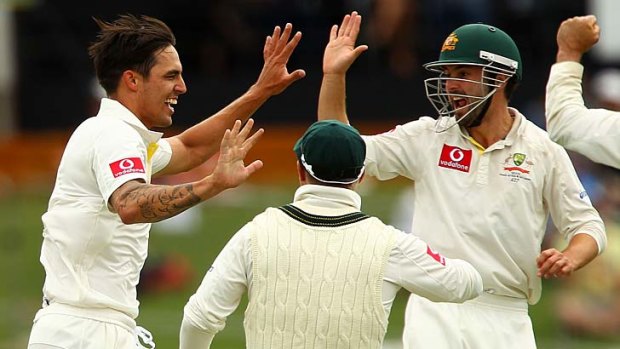 Mitchell Johnson celebrates after taking the wicket of Dean Elgar.