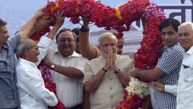 Flower power: Narendra Modi receives a  garland from supporters after his landslide victory.