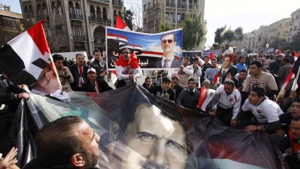 Turmoil &#8230; pro-government demonstrators with an image of the President in Damascus on Friday.