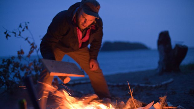 Nick Brennan stokes a campfire at Martin Head.