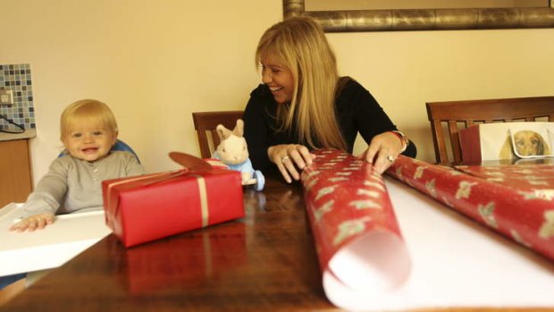 Cheques and balances: Emily Lamb, with son Rufus, wrap Christmas gifts for friends and family in Britain: