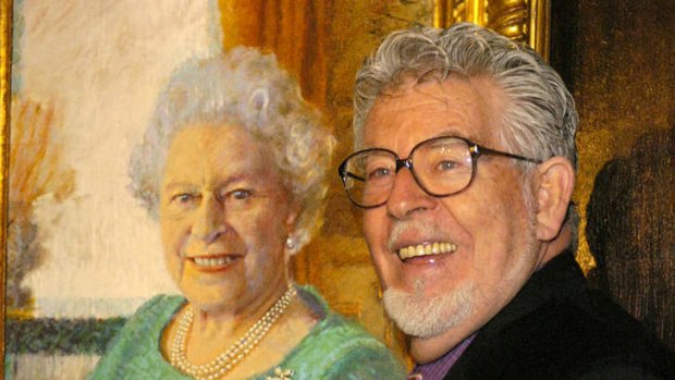 Rolf Harris poses beside his portrait of Queen Elizabeth II at Buckingham Palace in December, 2005.