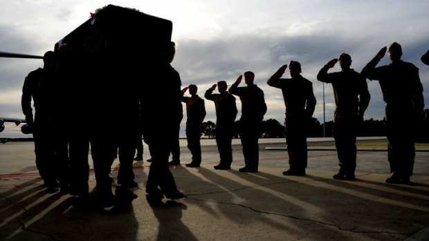 Soldiers from the Special Air Service Regiment salute as the casket of Sergeant Blaine Diddams is marched off the C-17 at RAAF Base Pearce, WA.