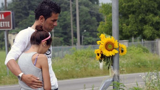 Colombian cyclist Diego Alejandro Tamayo Martinez comforts a friend at the scene of the accident.