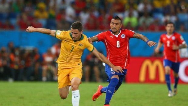 Good form: Arturo Vidal challenges Mathew Leckie during Australia's match with Chile at the World Cup.