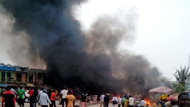 Smoke rises after a bomb blast in Jos, Nigeria, on Tuesday.  At least 118 people were killed in twin blasts timed for mass casualties.