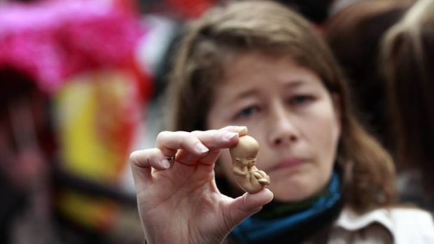 Cultural conflict ... a pro-life campaigner holds up a model of a 12-week-old embryo outside the Marie Stopes clinic.