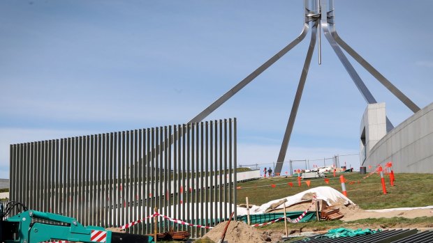 A security fence is installed across the lawns of Parliament House in Canberra.