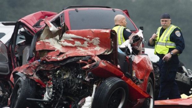 Picking up the pieces: Crash investigators at the scene of the crash in California where six people died.