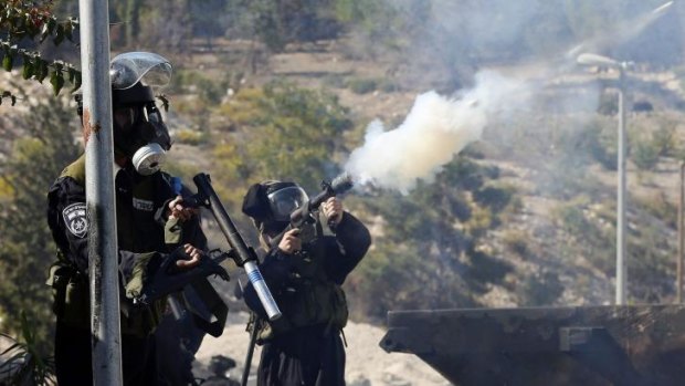 Wednesday: An Israeli police officer fires a tear gas canister during a confrontation with Palestinians in Issawiya.