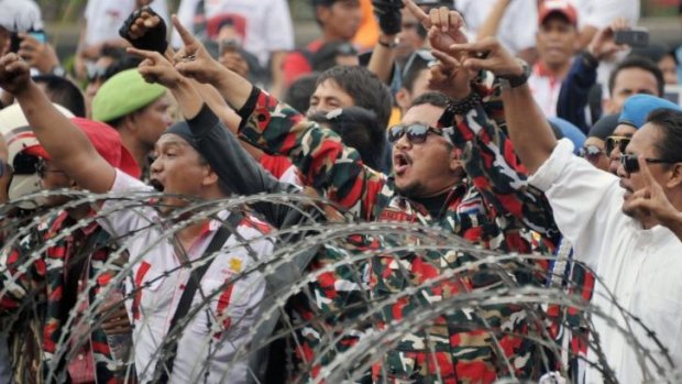 Chanting and singing: Presidential candidate Prabowo Subianto's  supporters try to pass a police blockade near the Constitutional Court in Jakarta on Thursday.
