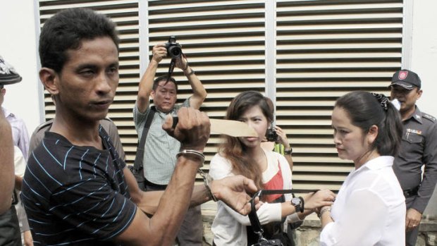 Thai suspect Surasak Suwannachot, 26, holds a mock knife during a police re-enactment in Phuket yesterday of the attempted robbery that killed Michelle Smith.